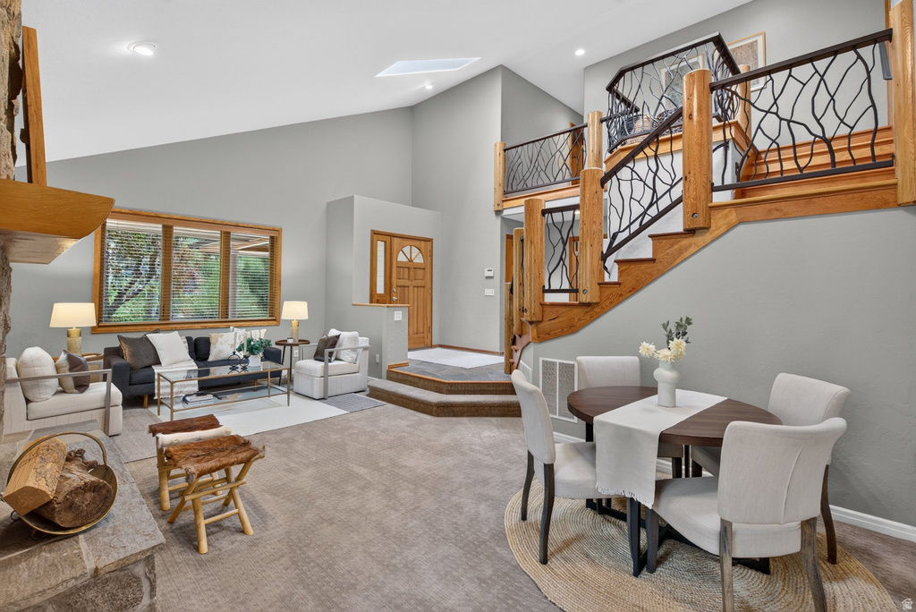 Two-story living area with a distinctive wood staircase featuring custom black ironwork railings