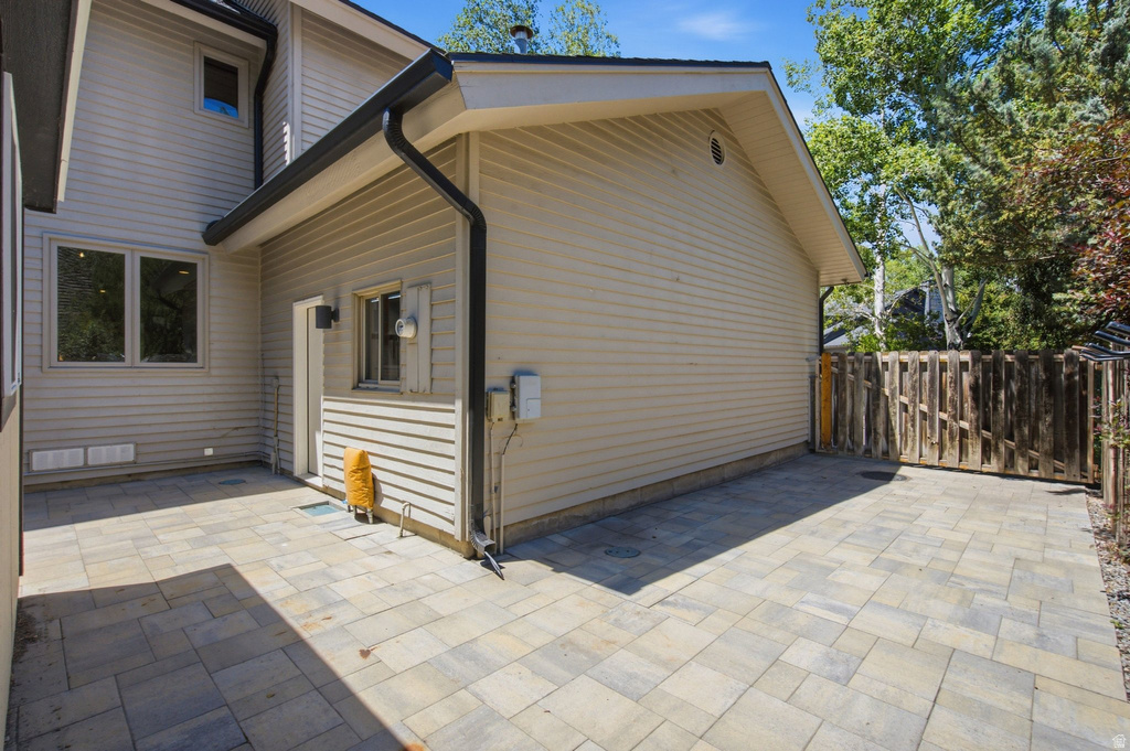 Expansive paver patio with a wood privacy fence and mature perimeter landscaping