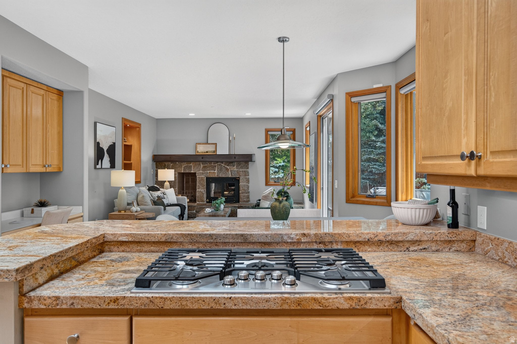 Kitchen featuring a built-in gas cooktop, light wood cabinetry, and speckled countertops