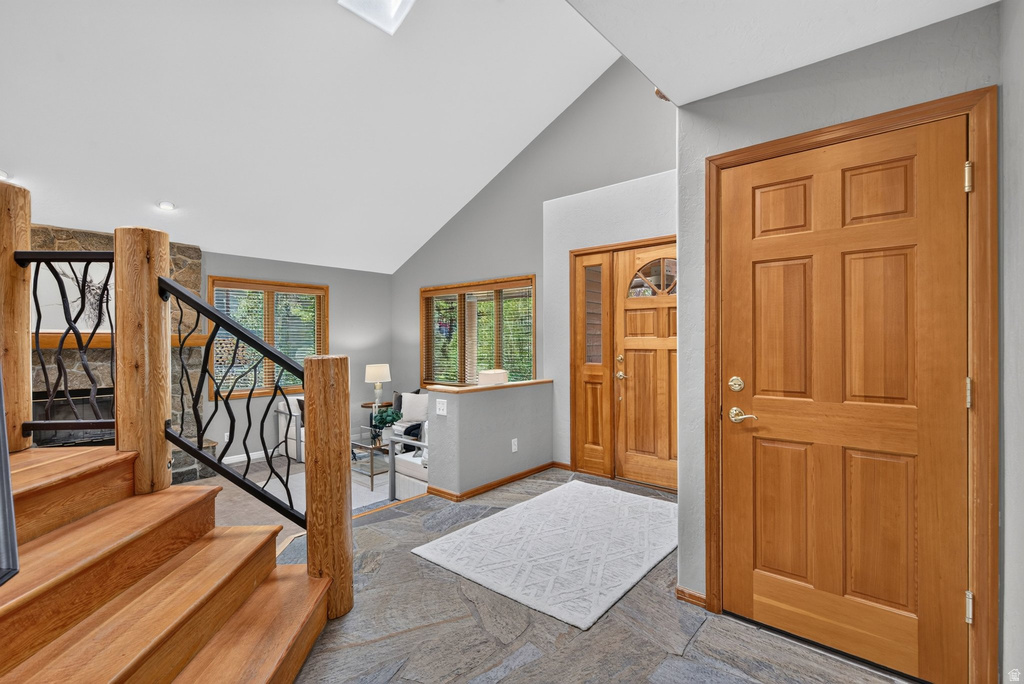 Entryway featuring natural wood doors, flagstone flooring, and a skylight