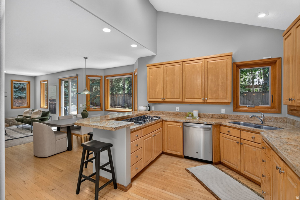 Kitchen featuring light wood cabinetry, stone countertops, a stainless steel dishwasher, and a gas cooktop