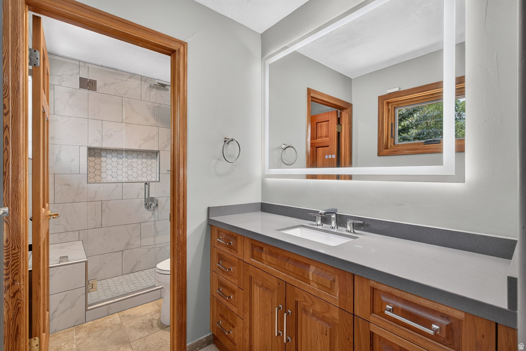 Bathroom featuring a wood-finish vanity with a light gray countertop and integrated sink