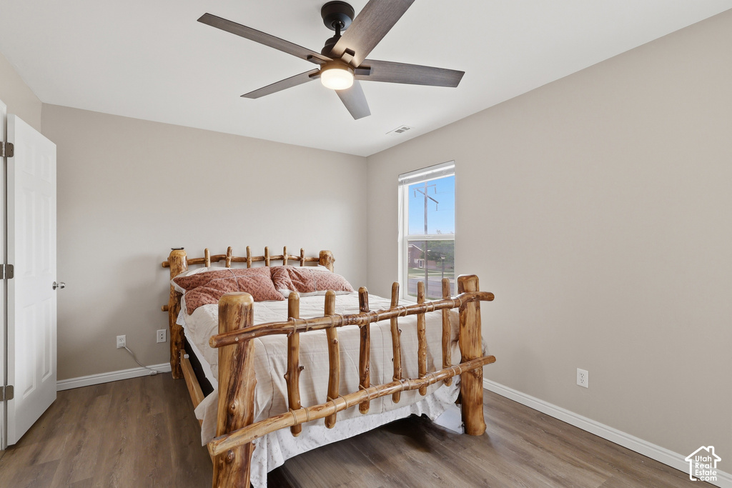 Room featuring light-toned walls, wood-finish flooring, a contemporary ceiling fan with integrated lighting, and a window providing natural light