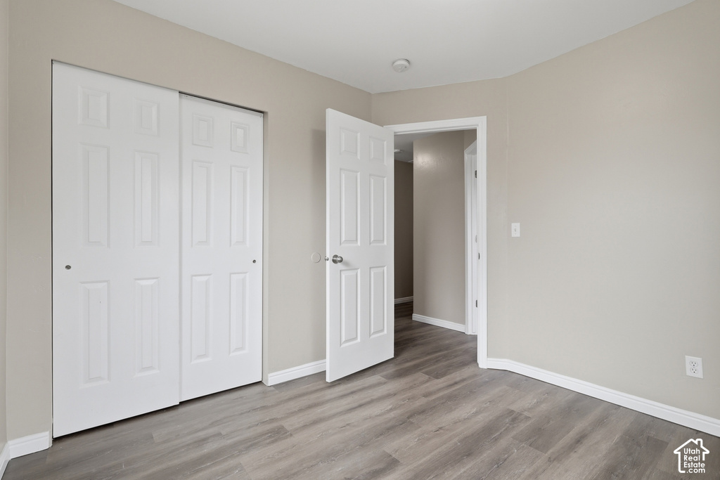 Room featuring wood-finish flooring, light neutral wall paint, and white trim