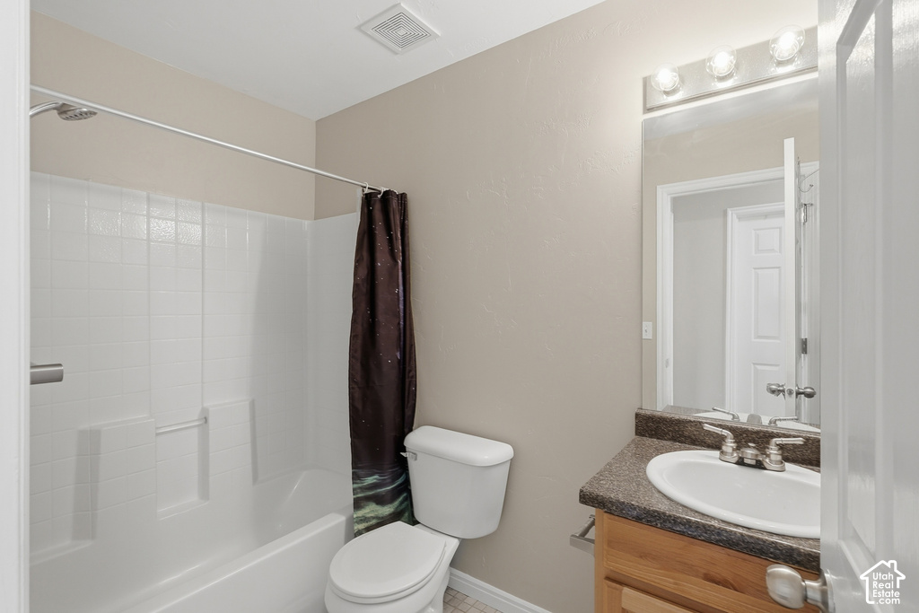 Bathroom featuring a shower/tub combination, a toilet, and a vanity with an integrated sink and countertop