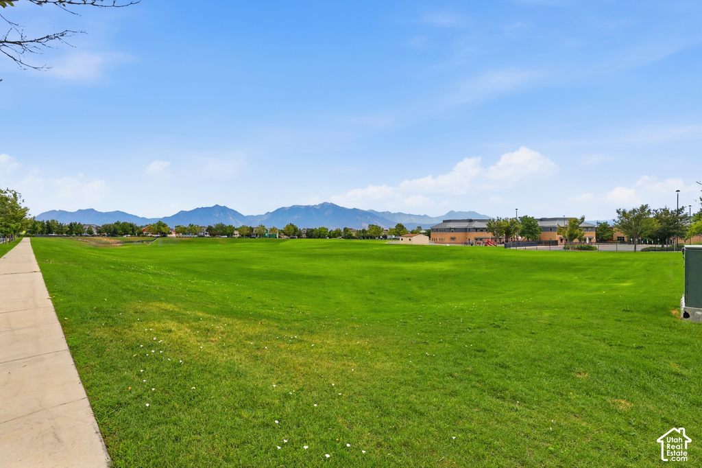 Expansive green space featuring a paved walkway and distant mountain range