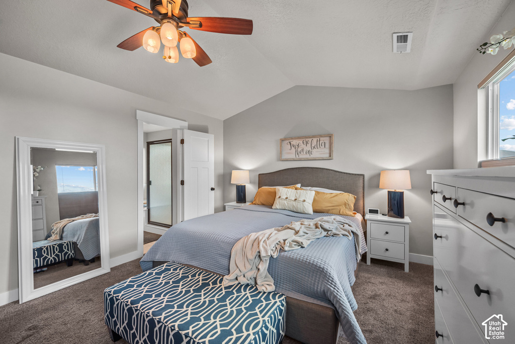 Carpeted bedroom featuring a vaulted ceiling and a ceiling fan with light fixture