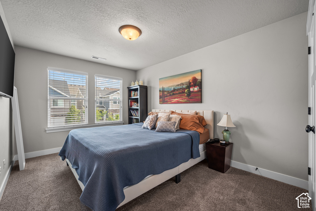 Spacious room featuring neutral paint, two windows with blinds, and durable carpeting