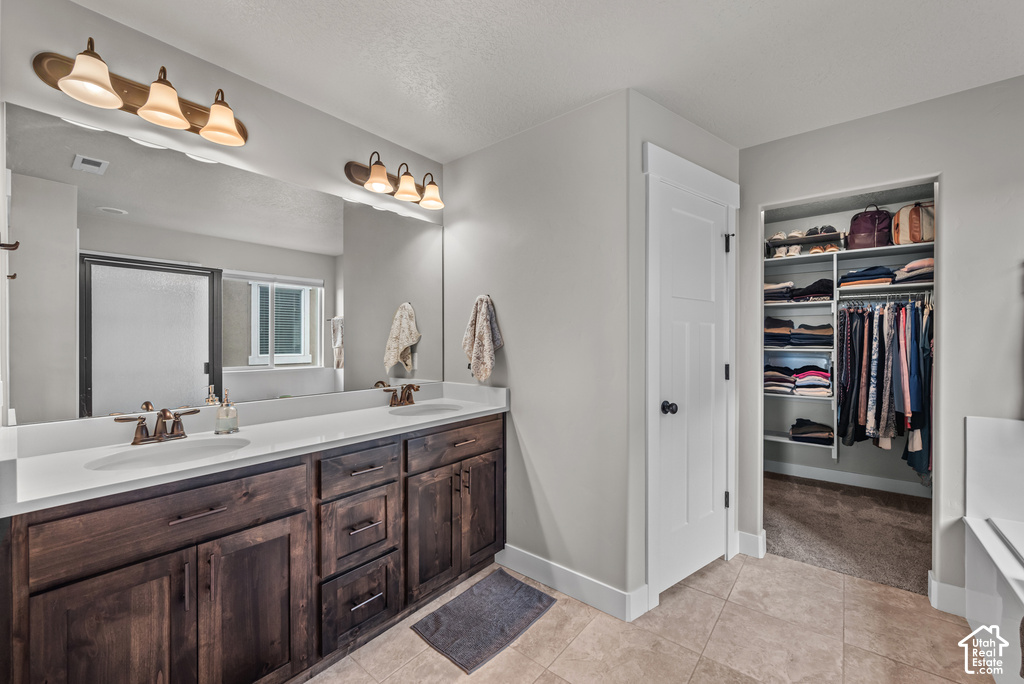 Spacious bathroom featuring a dual vanity with dark wood cabinetry and white countertops