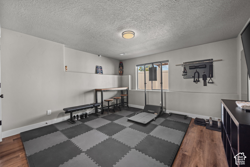 Multipurpose room featuring checkerboard puzzle mat flooring, light gray walls, a built-in window, and wood-finish flooring portions