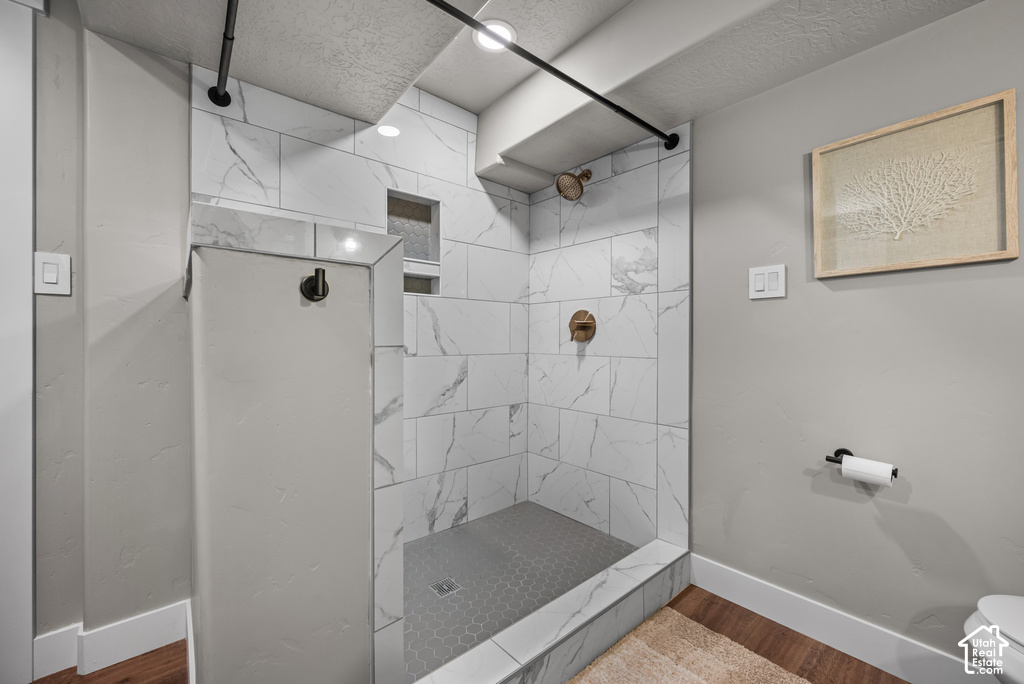 Contemporary shower featuring large format white tile with gray veining, a hexagonal tile floor, and a built-in shower niche