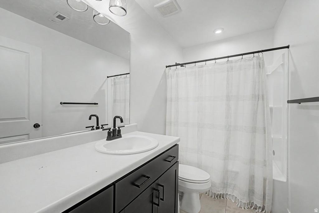 Bathroom featuring a single vanity with a white countertop, dark cabinetry, and black hardware