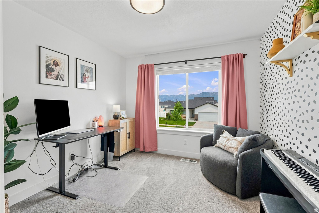 Bright room featuring a large window, carpeted flooring, and a decorative accent wall
