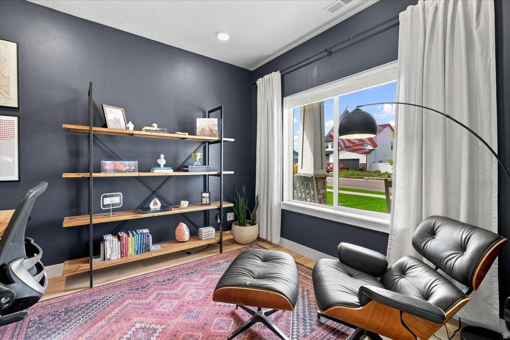 Spacious room featuring dark accent walls, wood-finish flooring, and a large window with white trim