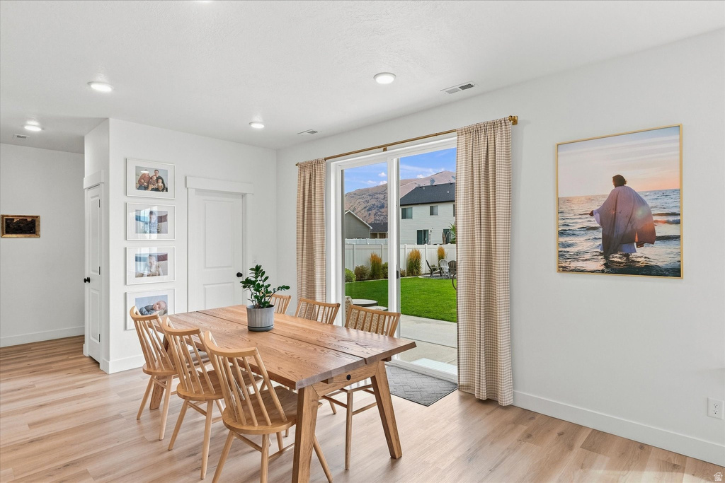 Spacious interior featuring light wood-finish flooring, recessed lighting, and white walls