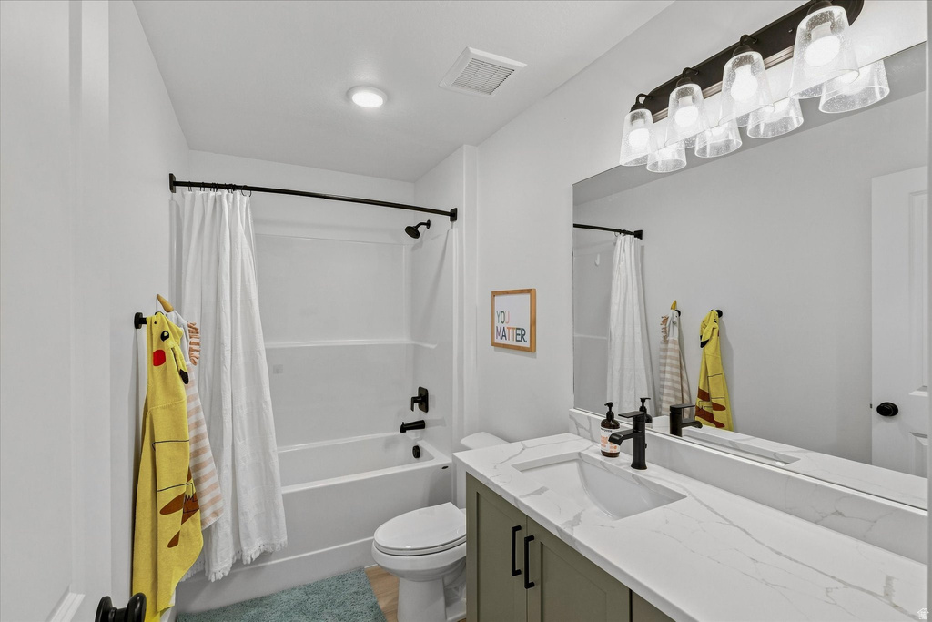 Bathroom featuring a single vanity with stone-finish countertop, undermount sink, and matte black fixtures