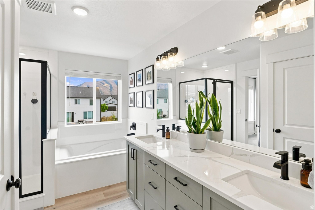 Bathroom featuring a dual vanity with light gray cabinetry, quartz countertops, and matte black fixtures