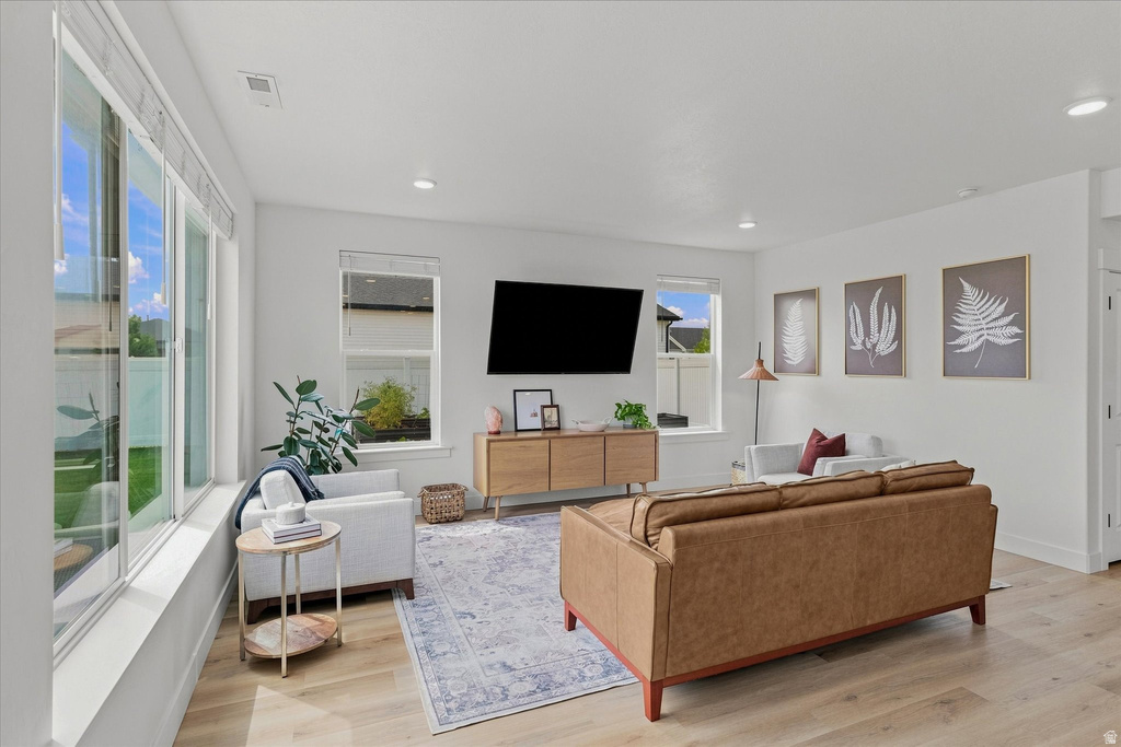 Open-concept living area featuring light wood-finish flooring and recessed lighting