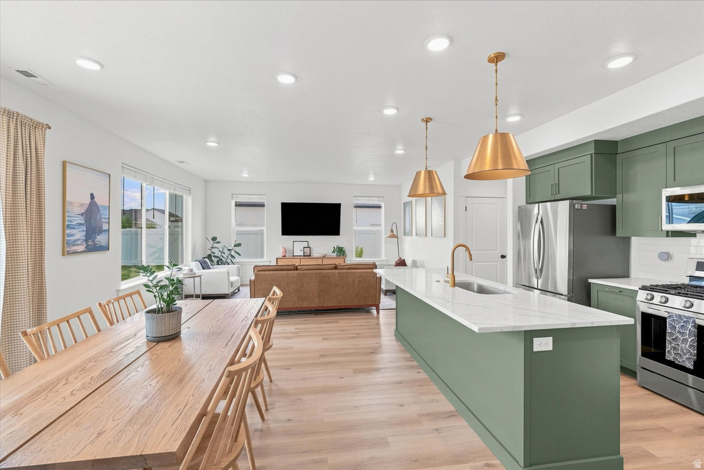 Open-concept living space featuring wood-finish flooring, recessed lighting, and large windows