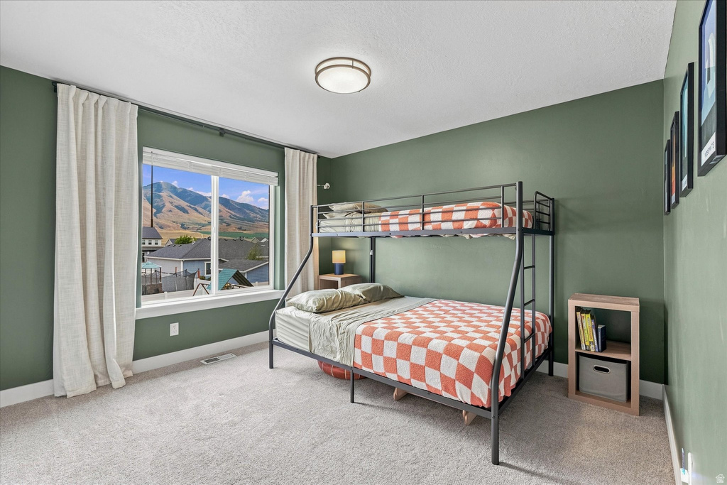 Spacious room with a large window framing distant mountains and houses