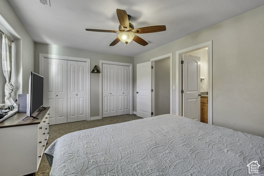 Bedroom featuring two bi-fold door closets, ceiling fan with integrated lighting, and carpet flooring