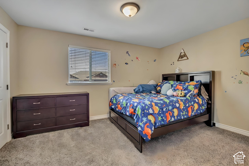 Plush carpeted room featuring a window with horizontal blinds, neutral-toned walls, a white baseboard, a ceiling-mounted light fixture, and a white interior door