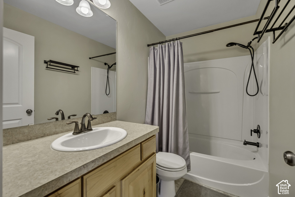 Bathroom featuring a vanity with light wood cabinetry, a light-toned countertop, and an undermount sink