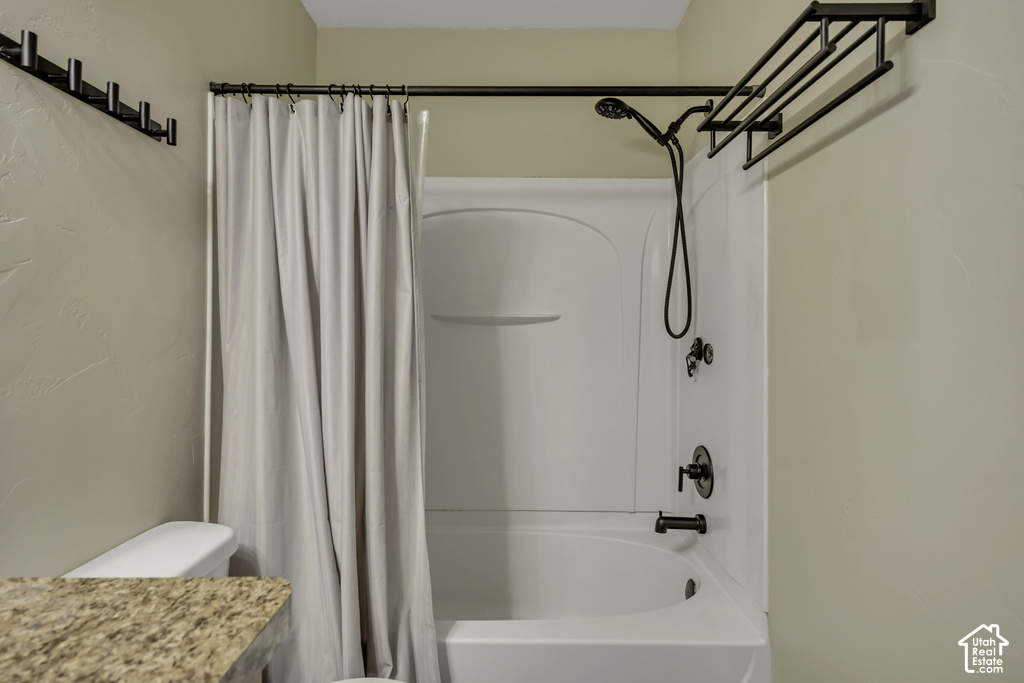 Bathtub with integrated shower, featuring oil-rubbed bronze fixtures and a handheld showerhead