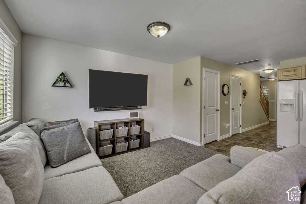Living area featuring neutral wall tones and textured carpet flooring