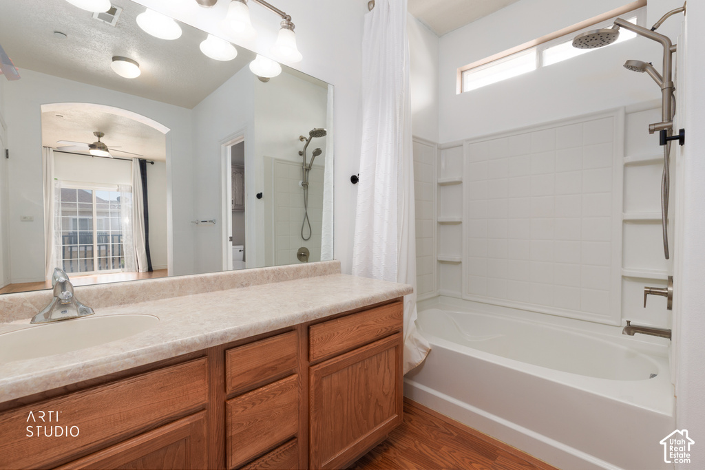 Bathroom featuring a light wood-finish vanity with a single basin sink, spacious countertop, and full-width mirror