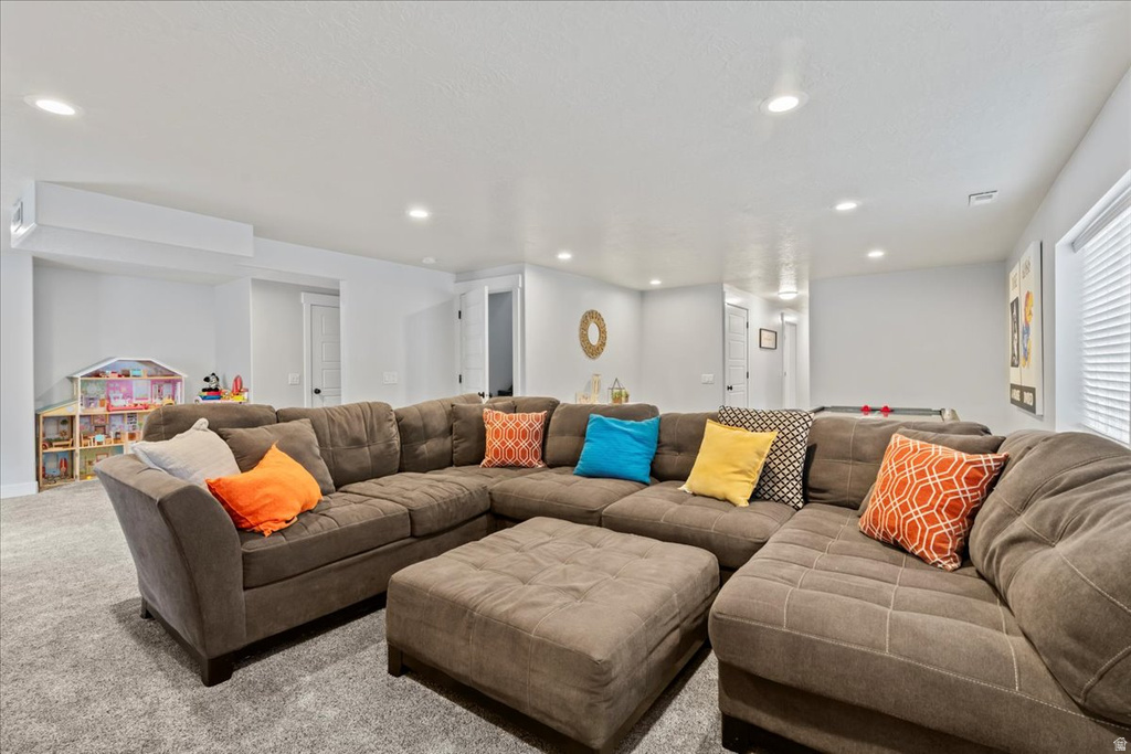 Spacious recreation room featuring recessed lighting, light gray wall paint, and gray carpet flooring