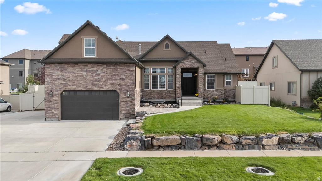 Stone and stucco exterior with a dark garage door and an inviting front entry
