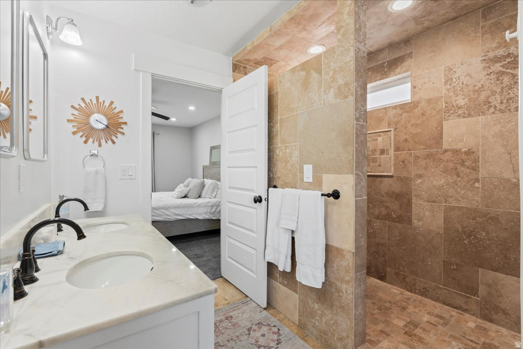 Bathroom featuring a dual vanity with undermount sinks, stone countertops, and dark bronze fixtures