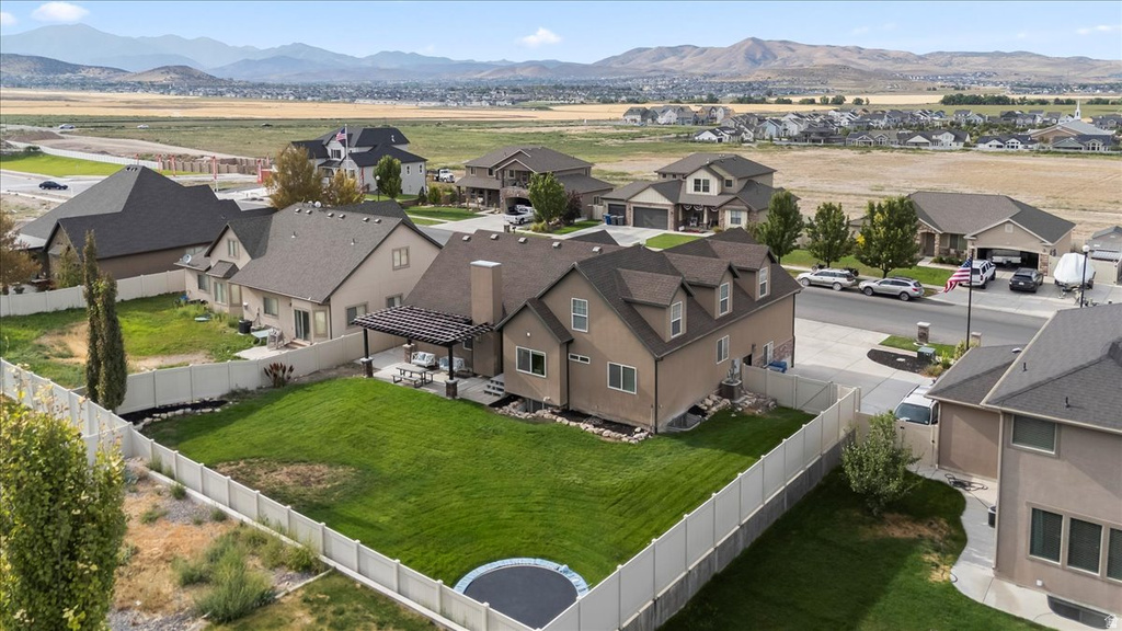Expansive backyard featuring a manicured lawn, full fencing, and a covered patio area