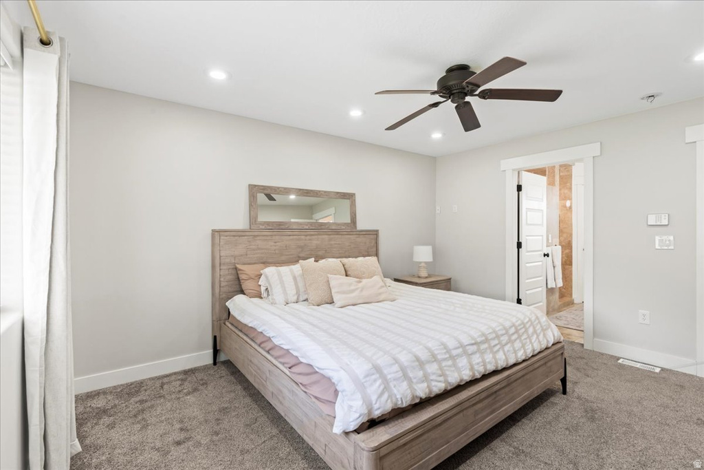 Carpeted room featuring a ceiling fan with integrated lighting, recessed lighting, and a doorway leading to a tiled bathroom