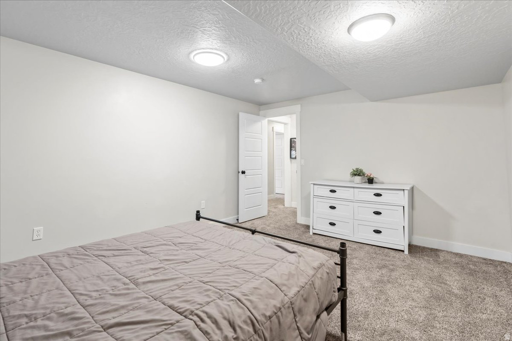 Room featuring neutral wall paint, textured ceiling, flush-mount lighting, and carpet flooring