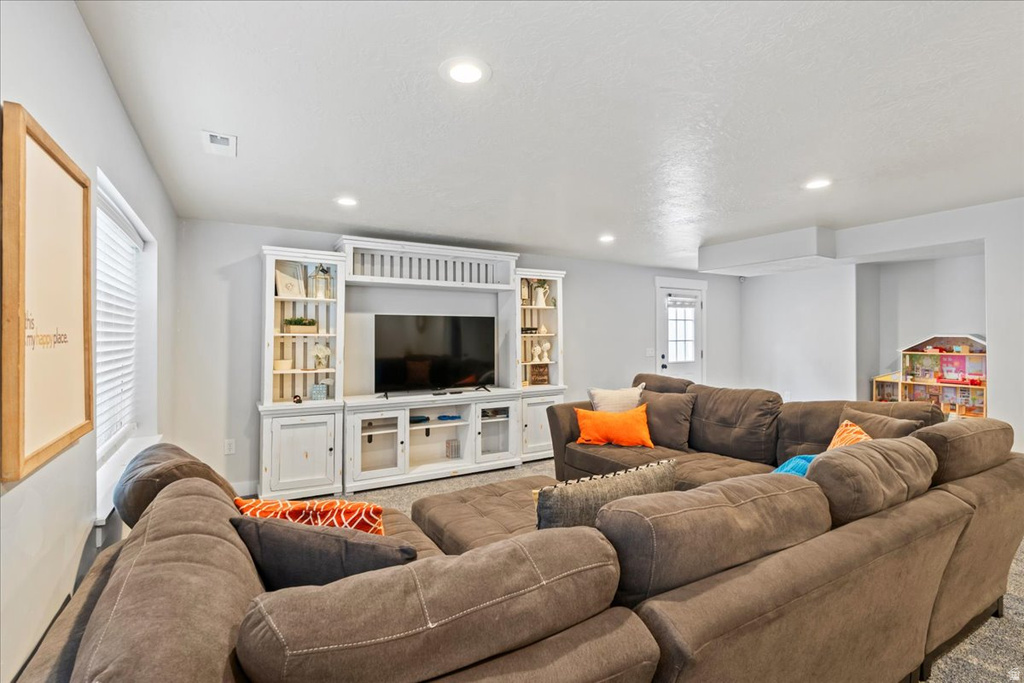 Entertainment space featuring a built-in media cabinet, recessed lighting, and light gray walls