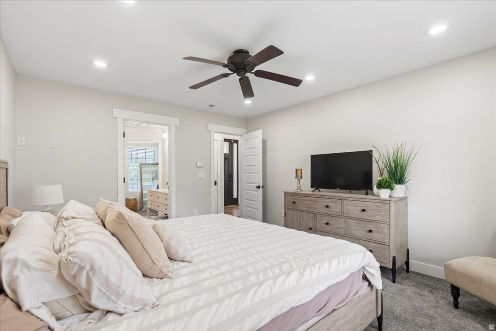 Bedroom with light gray walls, plush gray carpeting, and a dark bronze ceiling fan