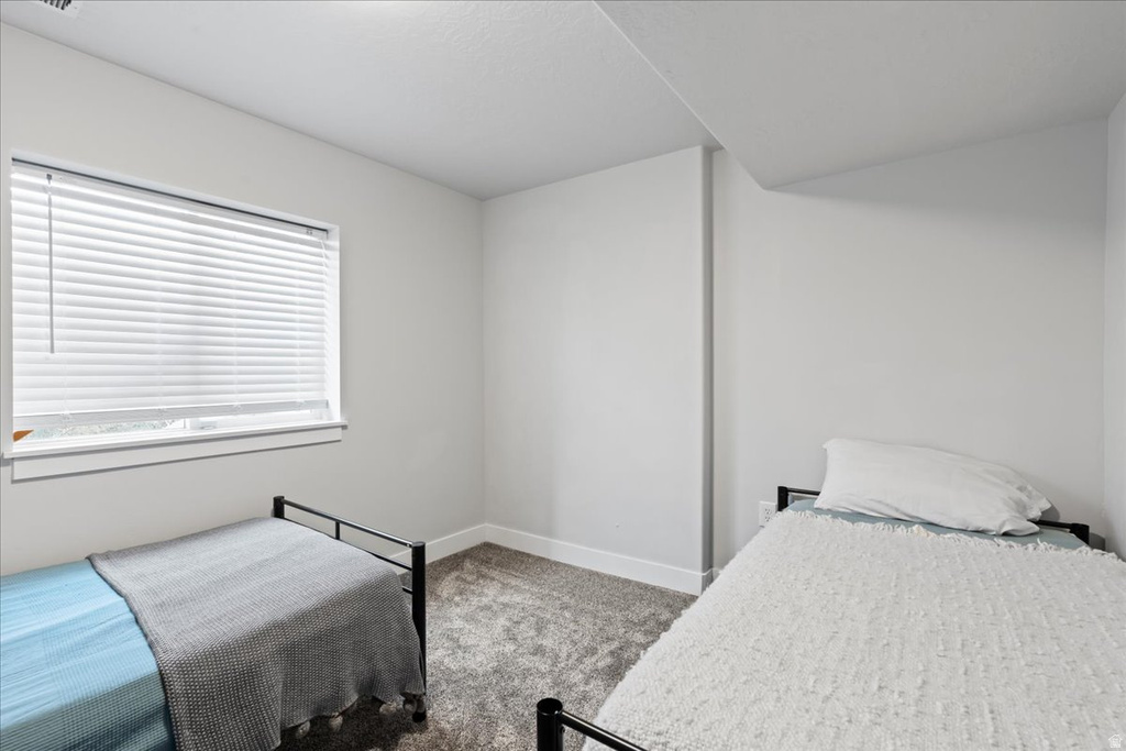 Bright room featuring light grey walls and grey patterned carpeting