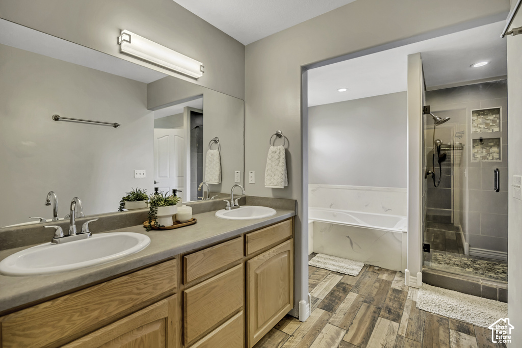 Bathroom featuring a dual vanity with light wood cabinetry and a large mirror