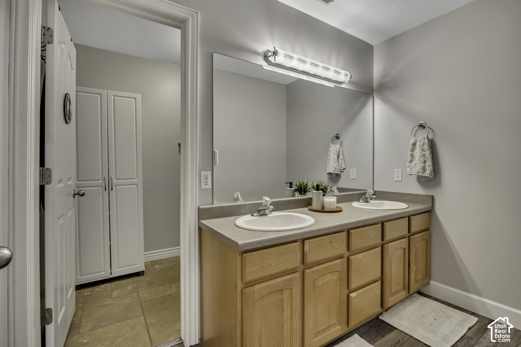 Double vanity with integrated sinks, a wide mirror, and overhead strip lighting