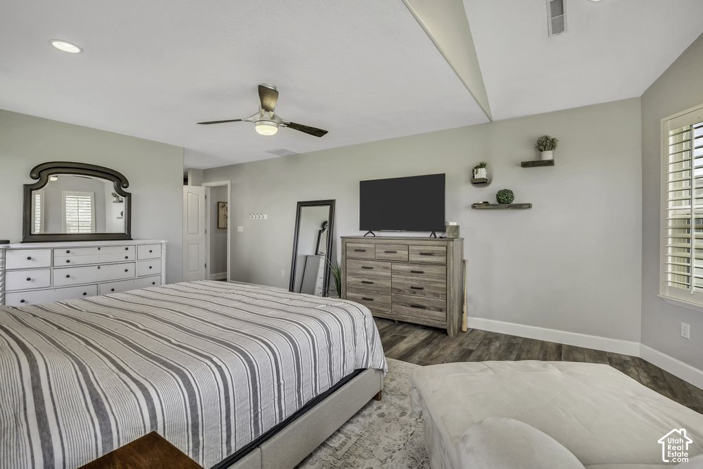 Spacious room featuring wood-finish flooring, a ceiling fan with integrated lighting, recessed lighting, and a window with plantation shutters