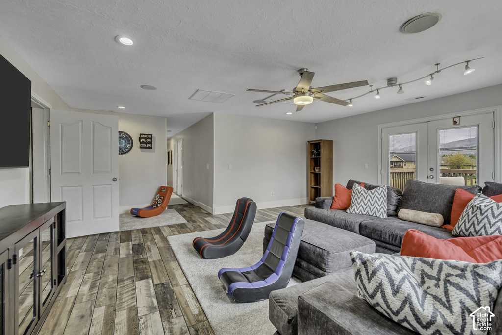 Spacious room featuring wood-finish flooring, recessed lighting, and a ceiling fan