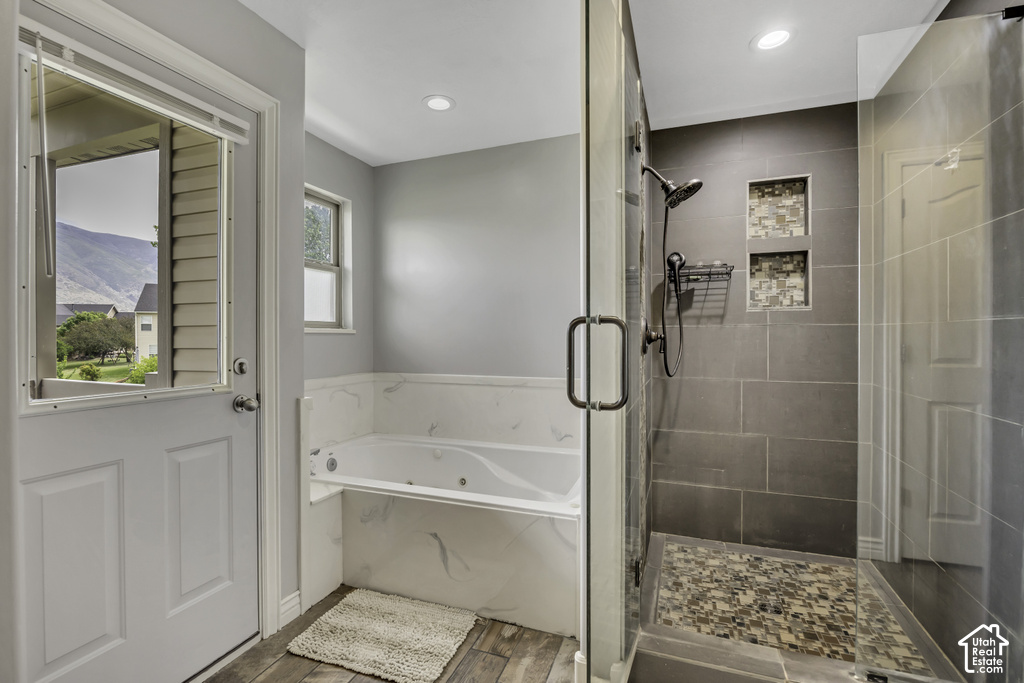 Glass-enclosed shower featuring large format tile, mosaic tile shower floor, and two recessed niches