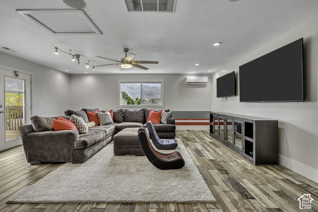 Spacious open room featuring wood-finish flooring, recessed lighting, and a ceiling fan