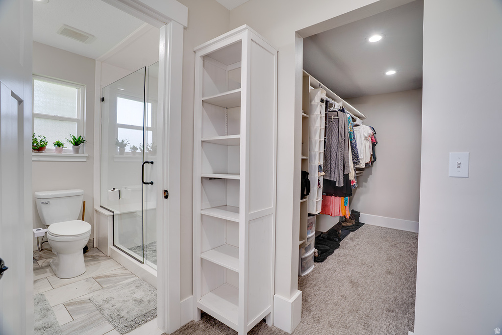 Modern bathroom featuring a glass-enclosed shower with a built-in bench, a window, and tile flooring