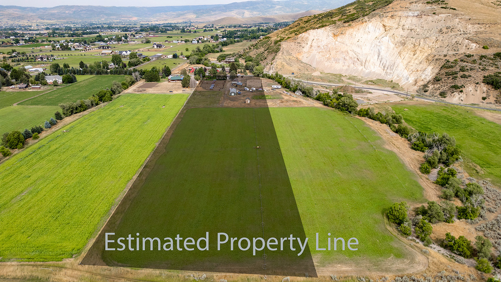 Expansive agricultural land featuring a verdant field and distant residential areas
