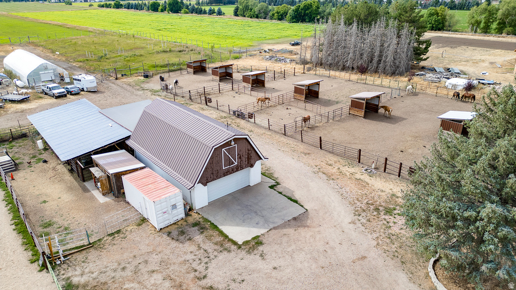 Expansive equestrian facility featuring a large barn with two garage doors and an attached shed