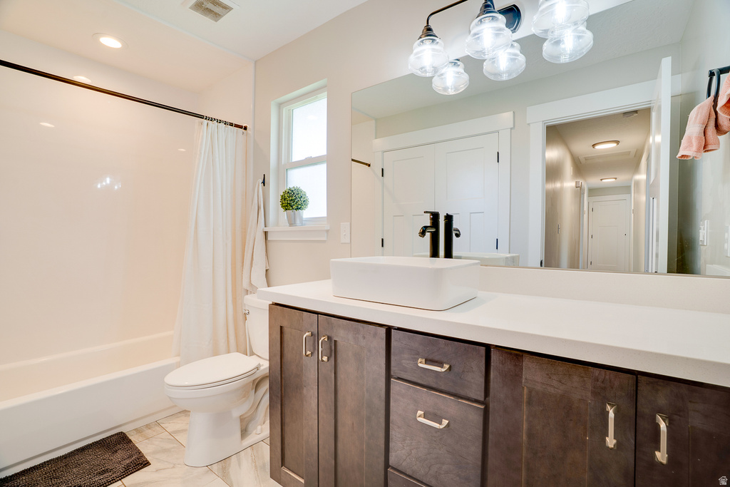 Bathroom featuring a modern vanity with a vessel sink, quartz countertop, and dark wood cabinetry