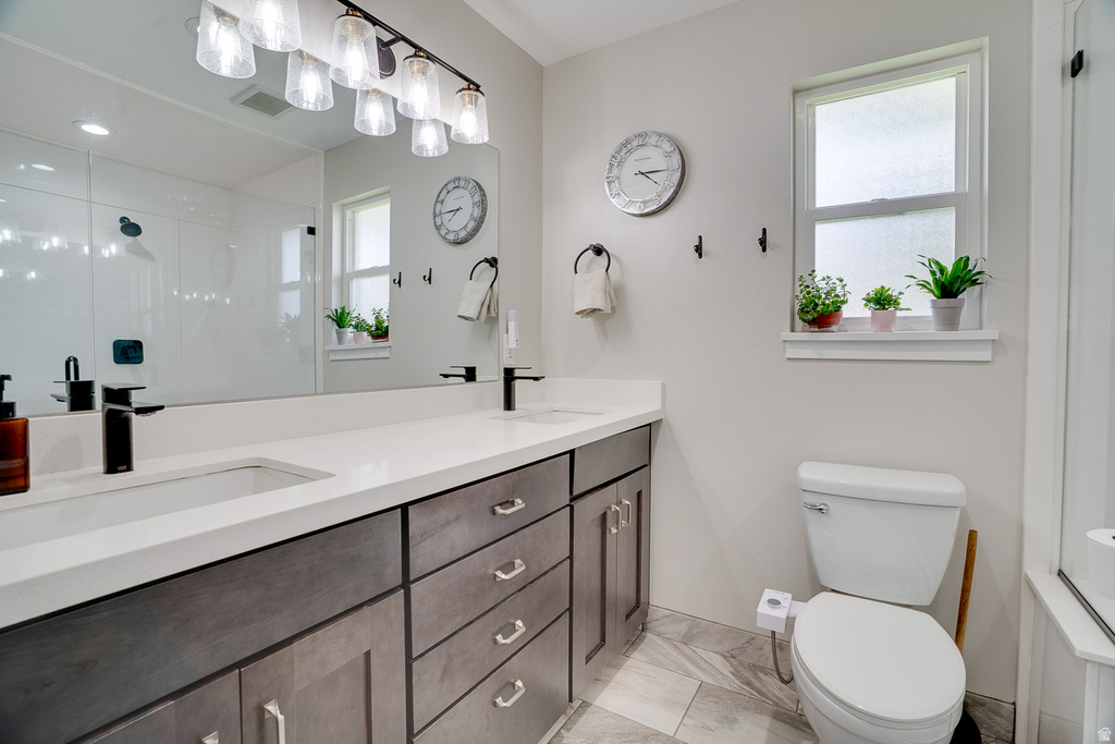 Bathroom featuring a dual vanity with white countertops, dark wood-finish cabinetry, and matte black fixtures
